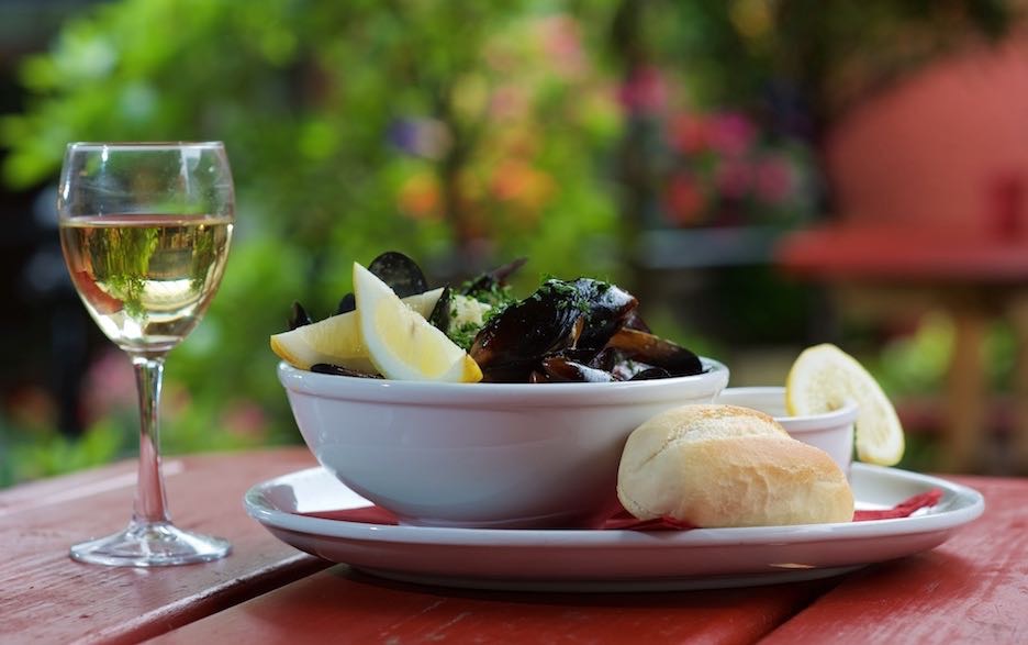dish of mussells, Moules Marinières, glass of white wine in beer garden at Tenby House, Pembs